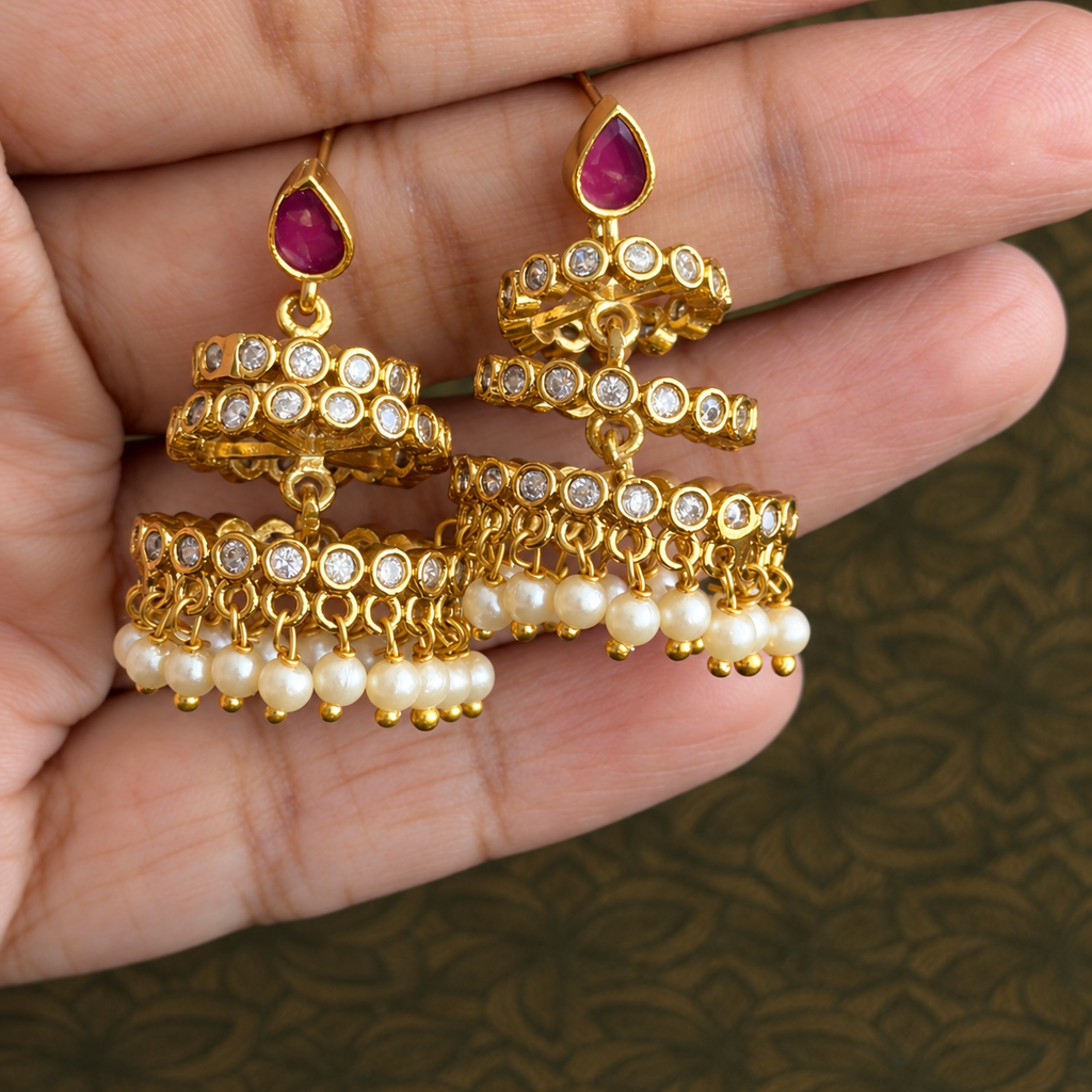 Pair of tiered gold-tone earrings with pink teardrop tops, clear stones and pearl-like drops