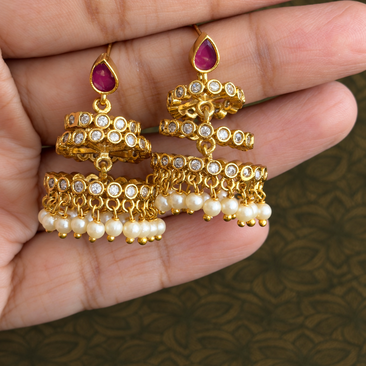 Pair of tiered gold-tone earrings with pink teardrop tops, clear stones and pearl-like drops