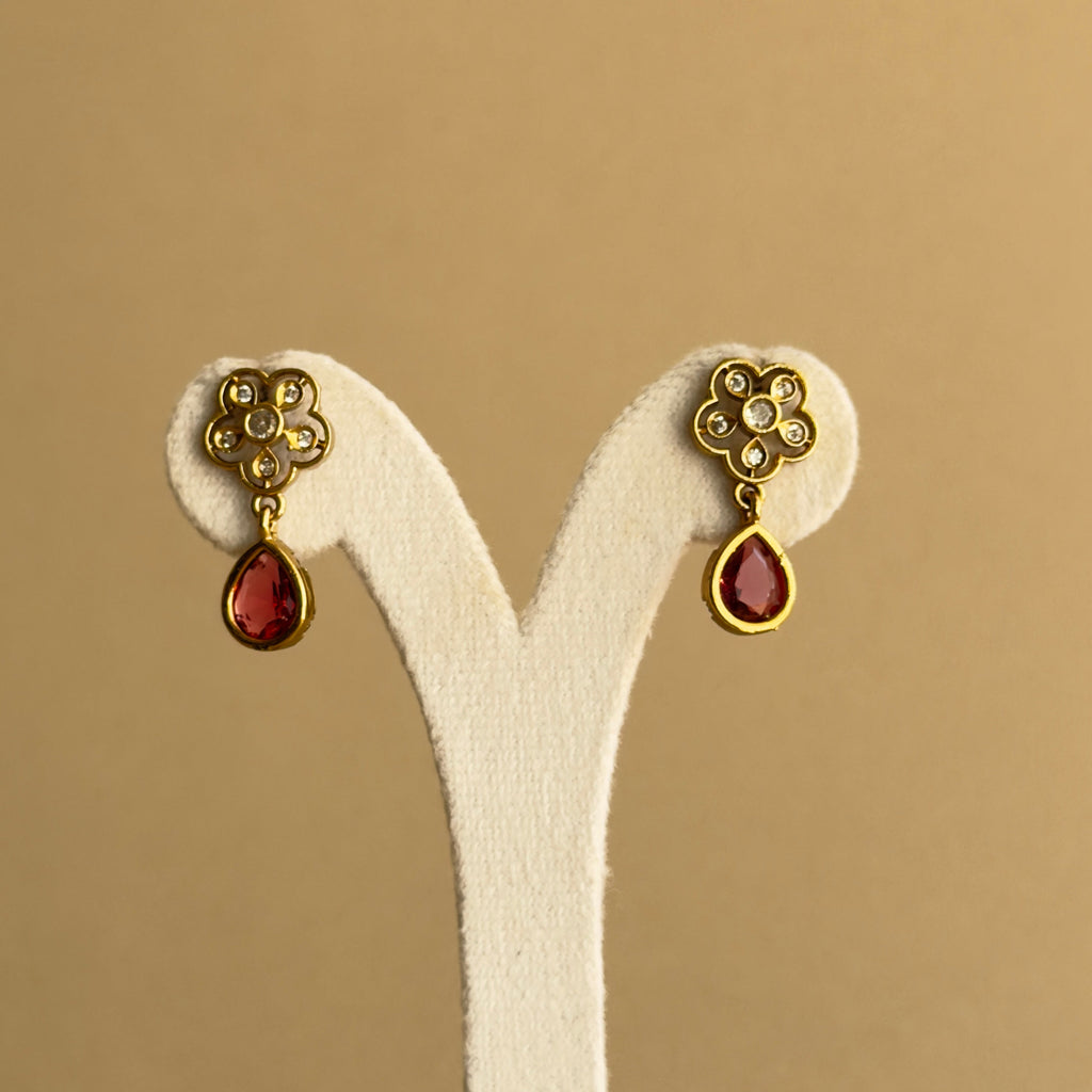 Matching floral gold-tone earrings with red teardrop accents